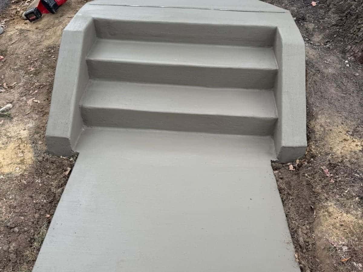 New broom-finished concrete steps and landing poured by Roso, with a wide walkway apron